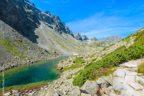 Hiking trail along beautiful lake in summer landscape of Starolesna valley, High Tatra Mountains, Slovakia