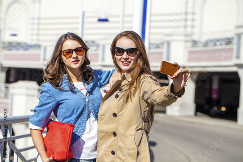 Two happy young beautiful women in sunglasses