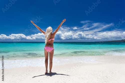 Woman in bikini with outstretched hands on tropical beach © photopixel
