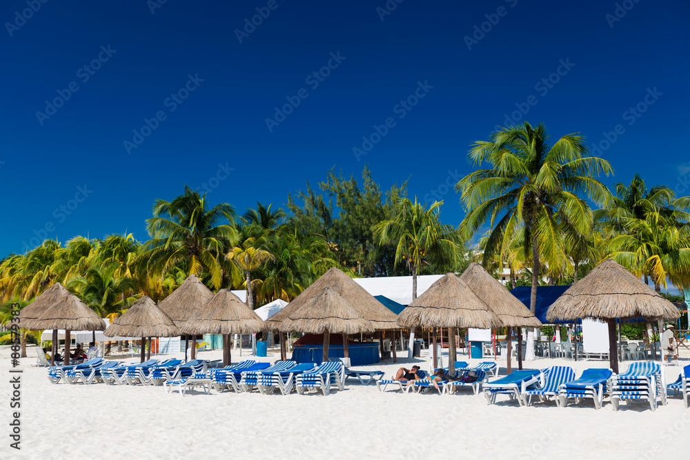 Caribbean beach with sun umbrellas and beds