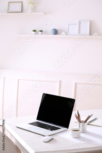Workplace with laptop in room