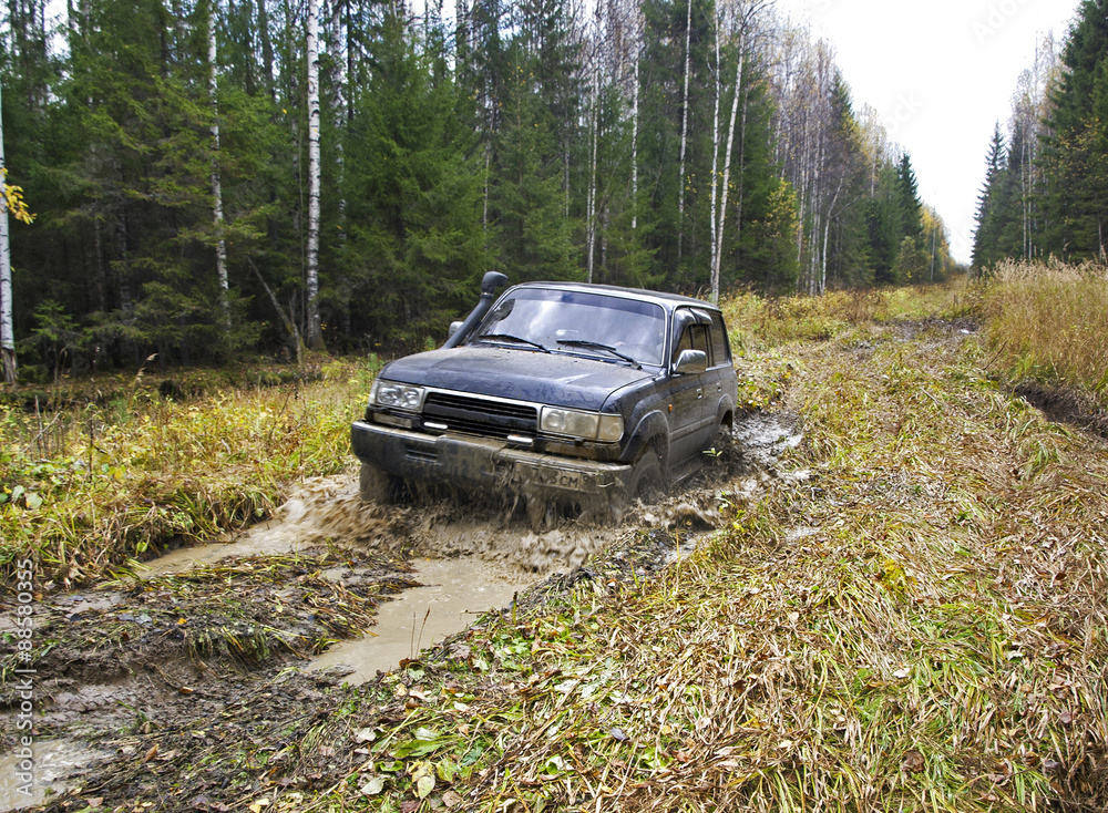 Russian Plain Road in the heart of Siberia. Flailing at breakneck speed wheel off-road vehicle stuck in a swamp