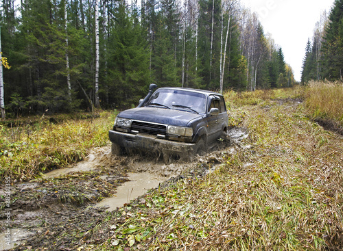Russian Plain Road in the heart of Siberia. Flailing at breakneck speed wheel off-road vehicle stuck in a swamp