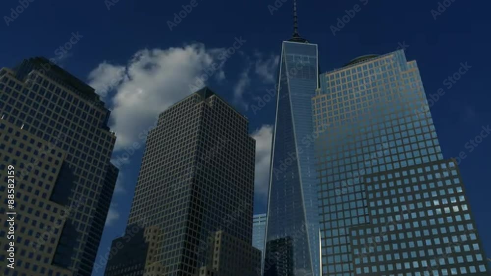 Clouds pass in time lapse over modern shiny skyscrapers of the downtown Manhattan skyline New York City