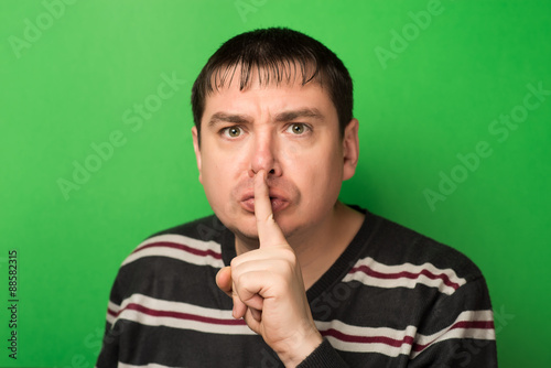 man finger near the lips, quietly photo