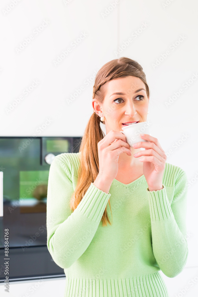 Woman drinking cup of coffee in domestic kitchen Woman drinking cup of coffee in domestic kitchen