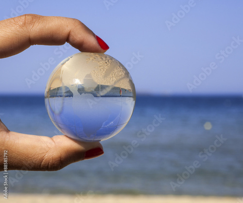 Human hand holding crystal globe.