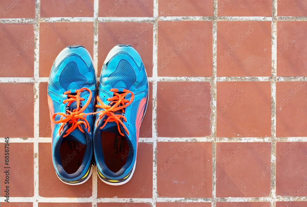 Blue sports shoes on terracotta floor