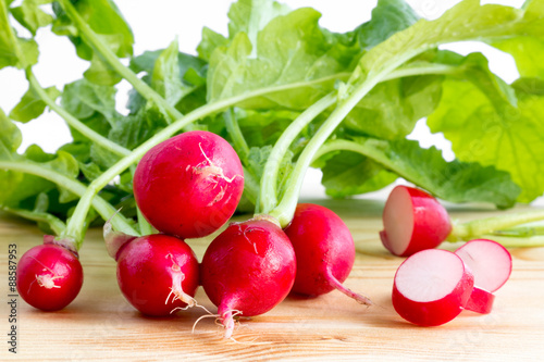 Fresh radishes, Raphanus sativus, on wooden plate