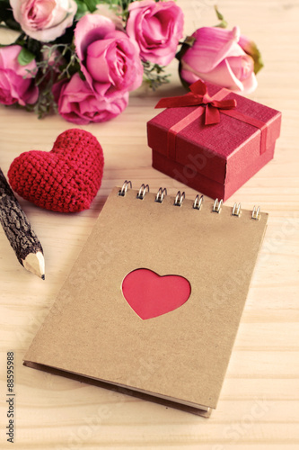 Blank notepad with red gift box and red heart shape