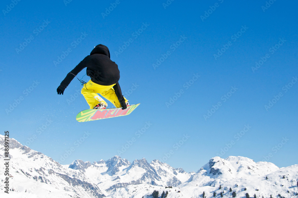 Snowboarder springt vor Bergpanorama