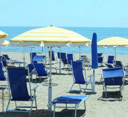 sunbeds with umbrellas in sunny beach in summer