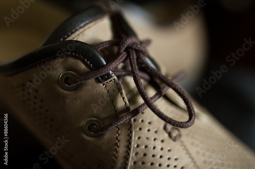 Lacing men's summer shoes on black background
