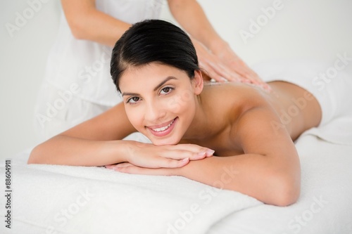 Smiling woman receiving a salt scrub massage