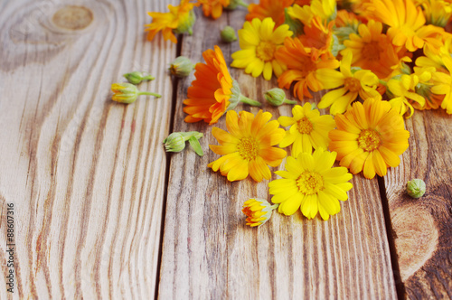 Yellow summer flowers on a wooden surface. Bouquet from a marigold. Calendula flowers. Holidays background in vintage style.