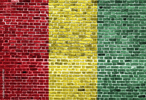 Flag of Guinea painted on brick wall, background texture