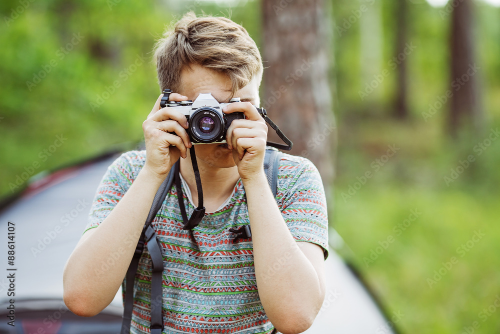 Man with photo camera outdoor with summer forest on background