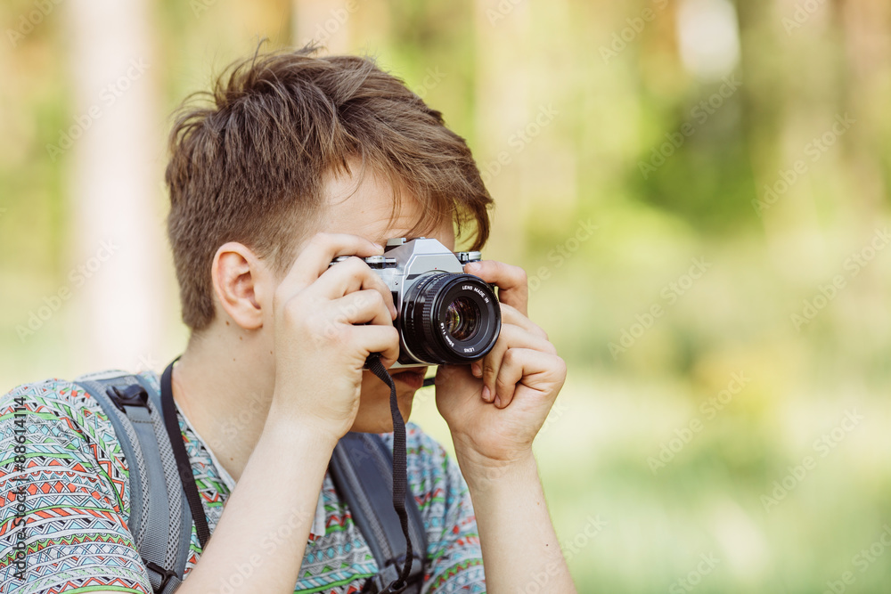 Man with photo camera outdoor with summer forest on background Man with photo camera outdoor with summer forest on background