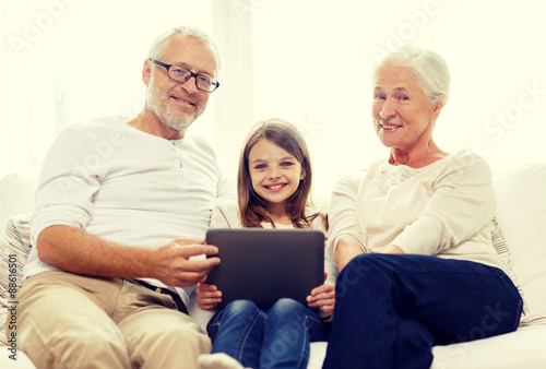 smiling family with tablet pc at home