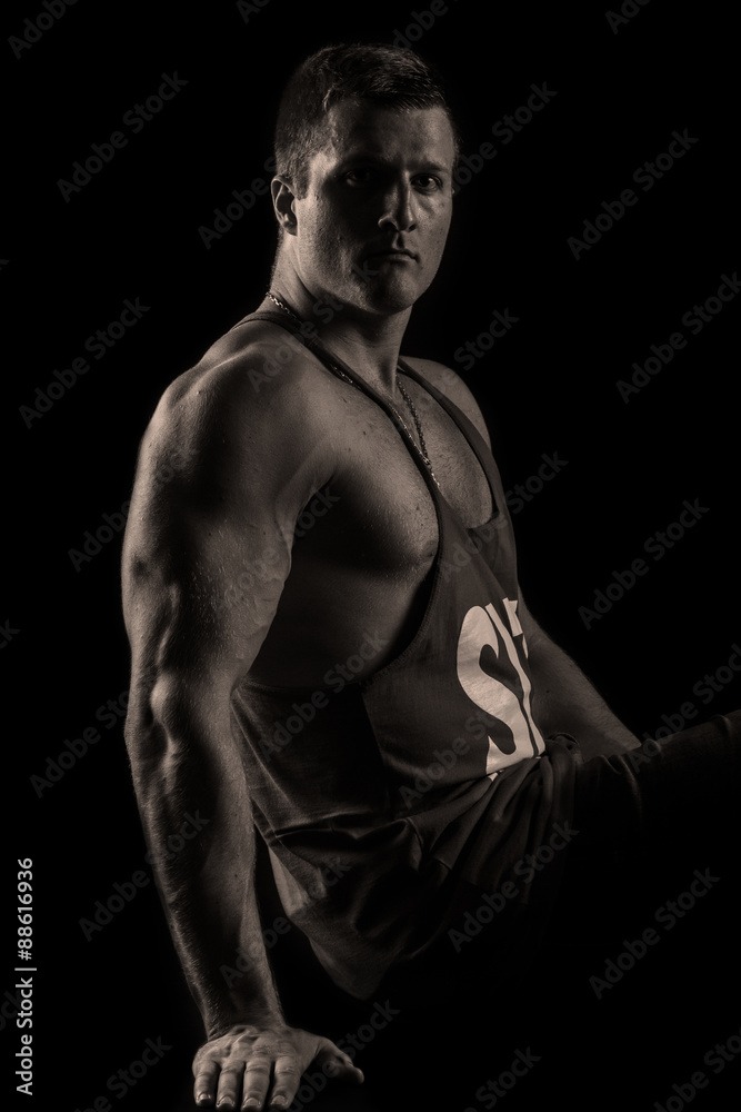 Strong athletic man on black background