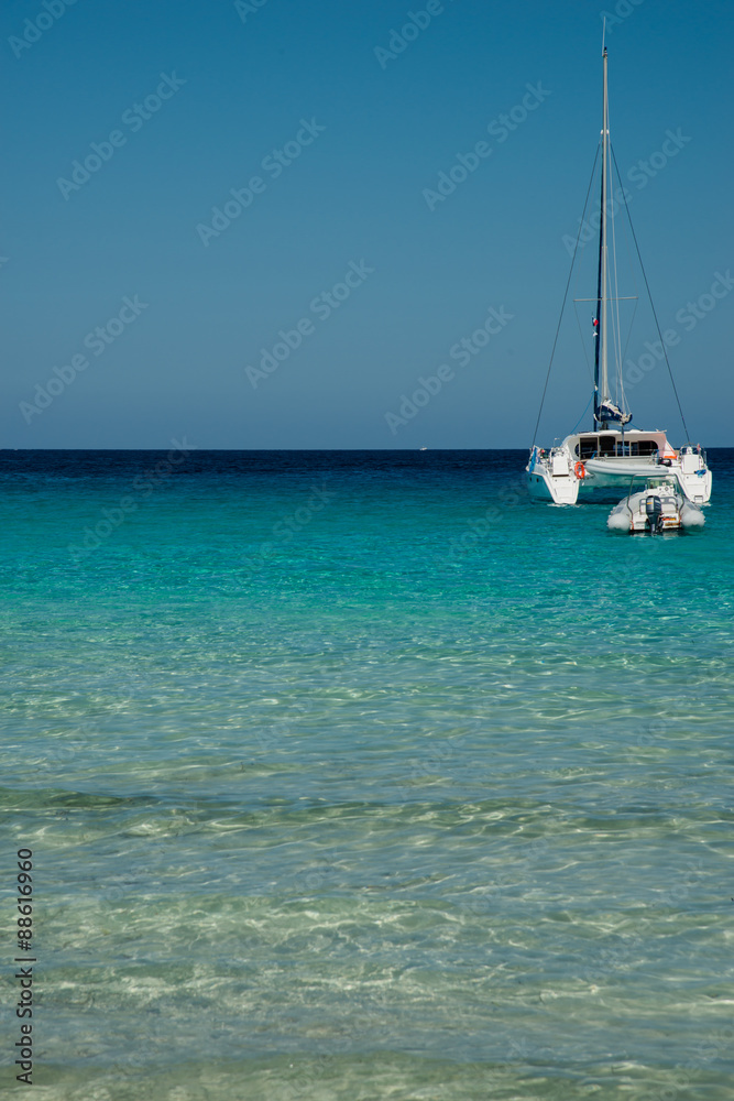 Catamaran mouillé dans une anse corse à l'eau turquoise