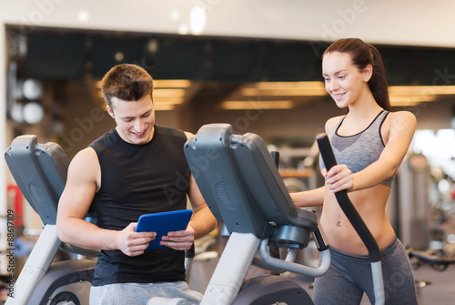 woman with trainer exercising on stepper in gym