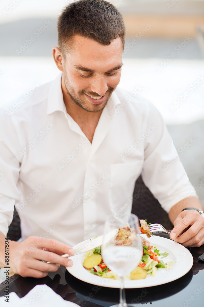 happy man eating salad for dinner at restaurant happy man eating salad for dinner at restaurant