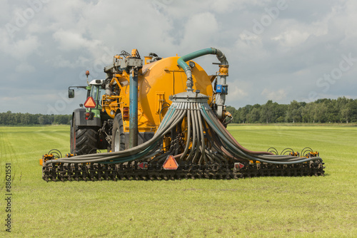 Injecting of liquid manure with tractor and yellow vulture sprea photo