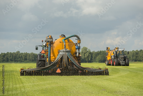 Injecting of liquid manure with two tractors and yellow vulture photo