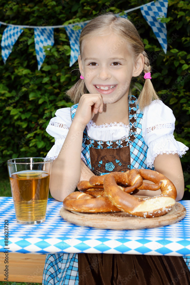 Mädchen in Dirndl als bayrische Tracht feiert Oktoberfest im Biergarten ...
