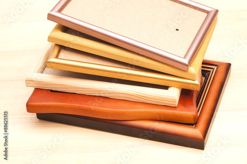 Stack of picture frames isolated on a wooden background