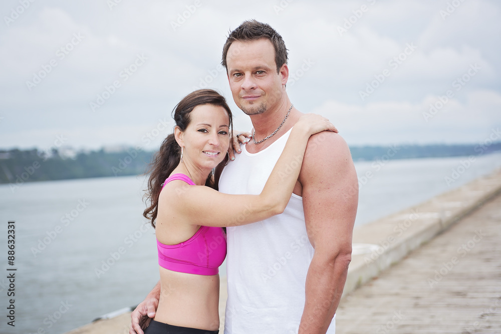 Sport woman and man jogging on road outside.