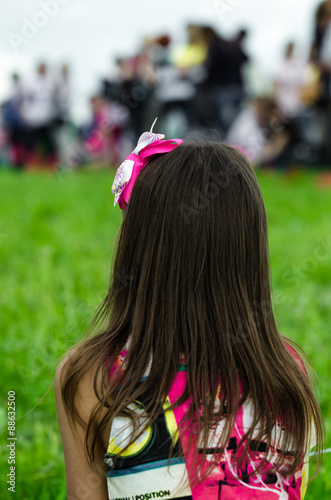 Girl looks out over field on celebrating people