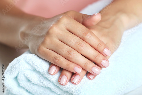 Woman hands with french manicure on towel close-up