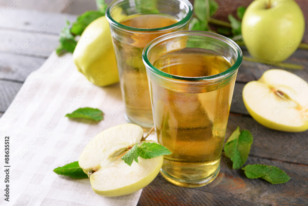 Glasses of apple juice on wooden table, closeup Glasses of apple juice on wooden table, closeup