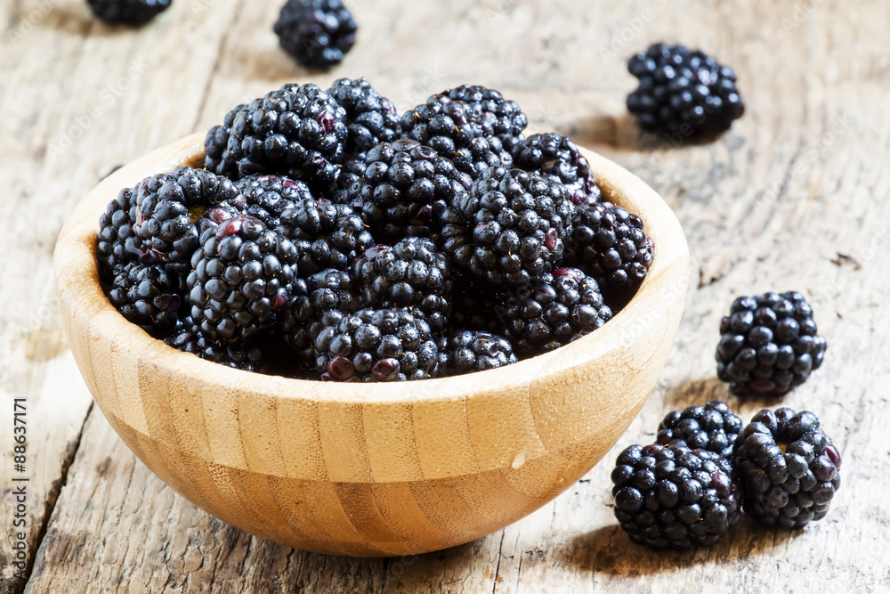 Fresh blackberries in a wooden bowl, selective focus Fresh blackberries in a wooden bowl, selective focus