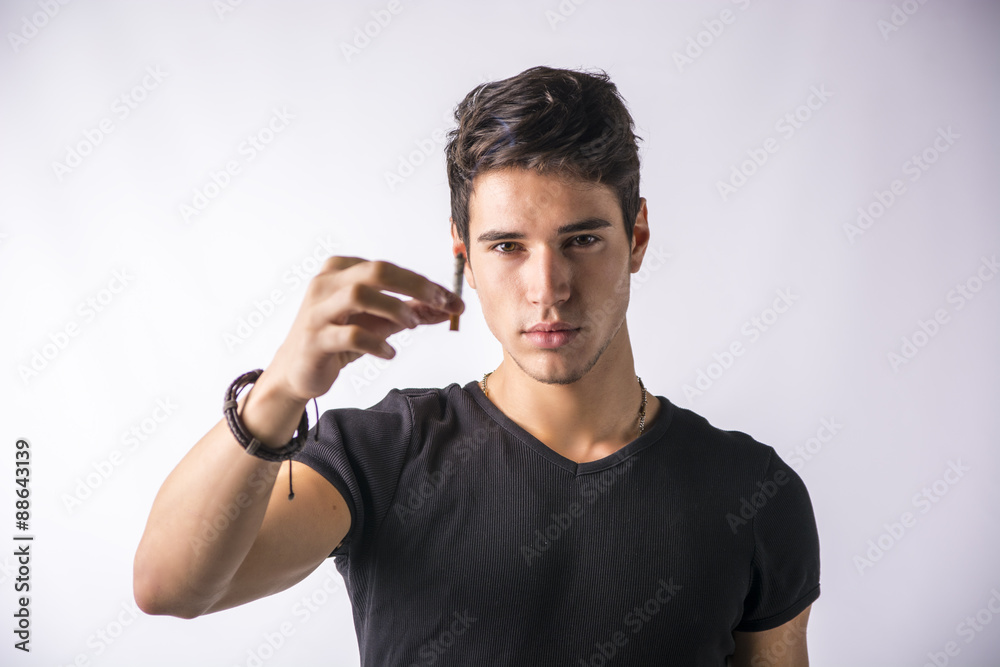 Handsome young man presenting and offering his cigarette Handsome young man presenting and offering his cigarette