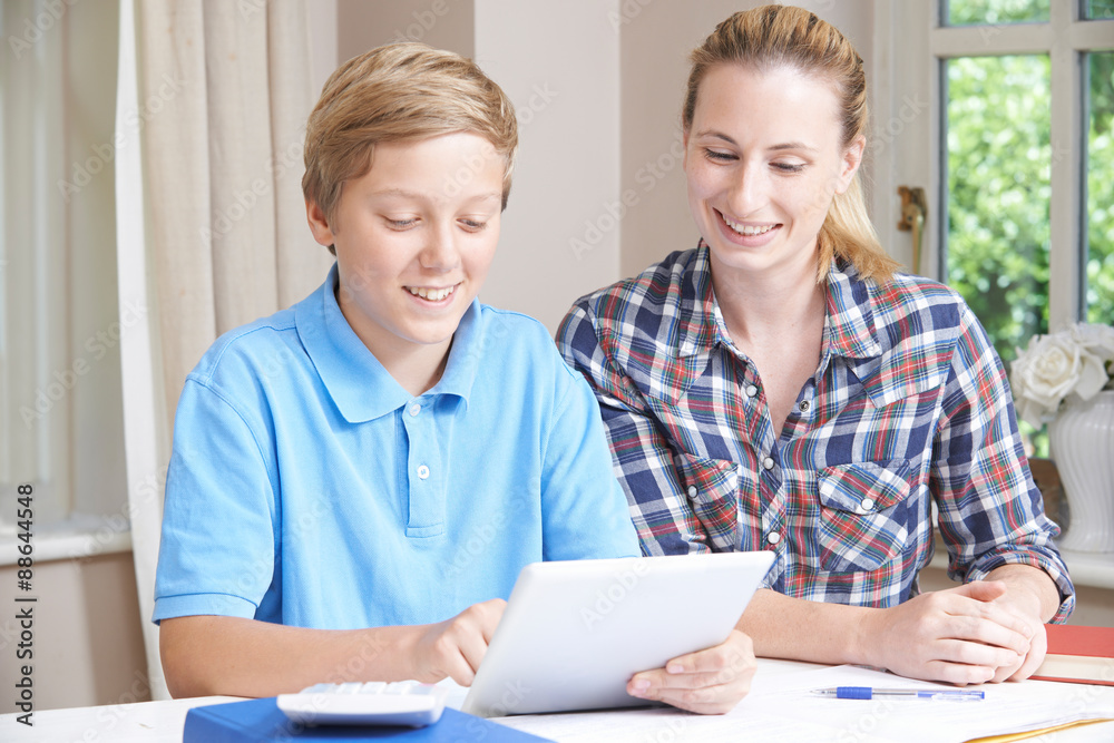 Female Home Tutor Helping Boy With Studies Using Digital Tablet