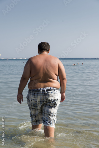 uomo obeso che entra in acqua © ief6599
