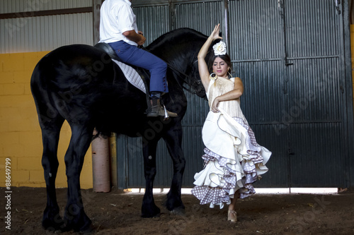 Bailaora de flamenco con caballo negro Árabe. Gitana flamenca y su caballo negro Árabe. Espectáculo de baile flamenco con caballos.