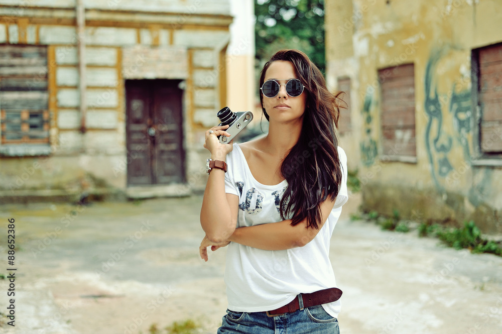 Beautiful young woman posing with old fashion camera