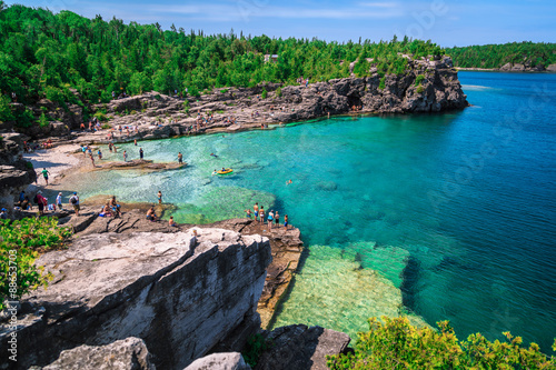 Bruce Peninsula at Cyprus lake, Ontario stunning, gorgeous amazing natural rocky beach view and tranquil azure clear water with people in background on sunny beautiful, day photo