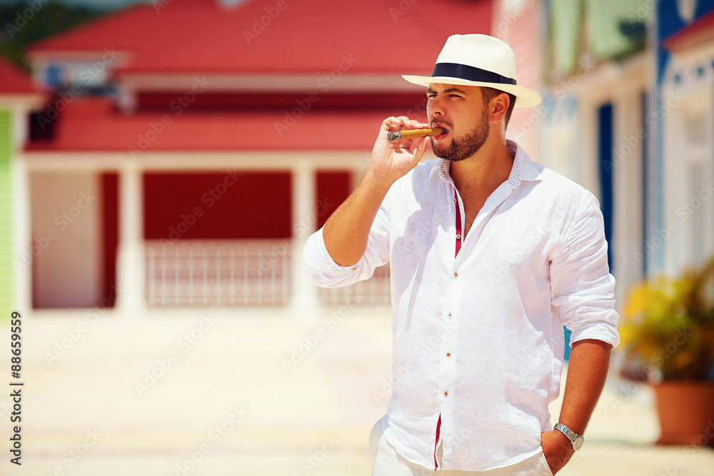 confident man smoking cigar on caribbean street - obrazy, fototapety, plakaty 