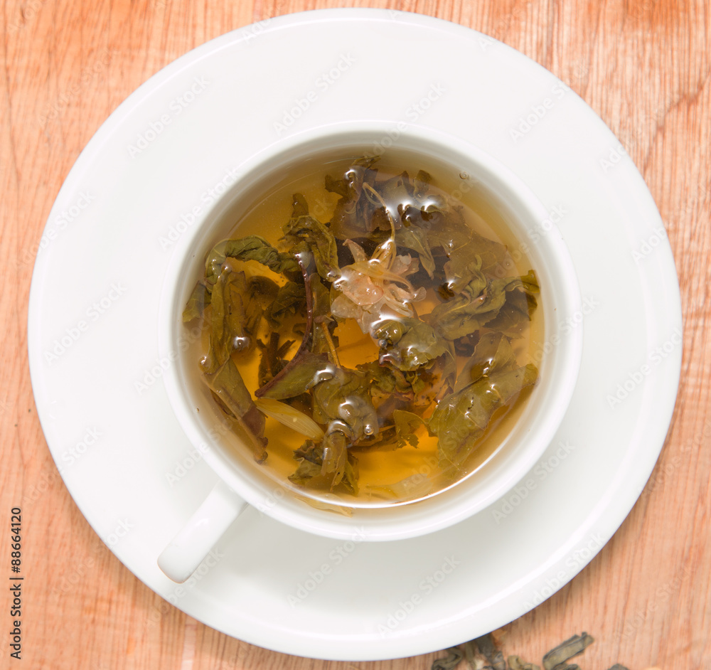 green tea with jasmine on a wooden background green tea with jasmine on a wooden background