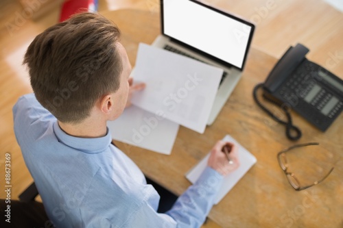Focused businessman reading document at desk