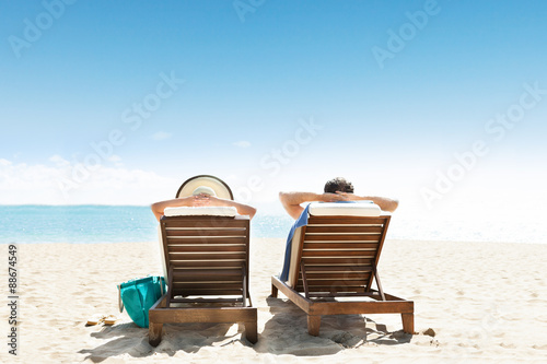 Фотография Couple Lying On Lounge Chair