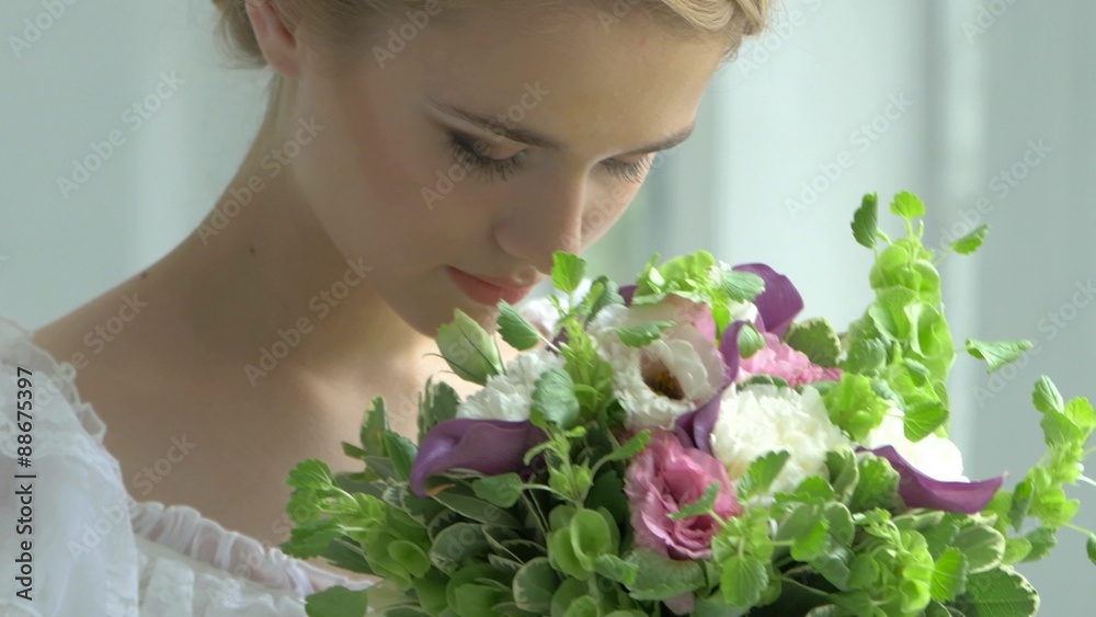 Blond girl in white dress with charming bouquet of flowers Blond girl in white dress with charming bouquet of flowers