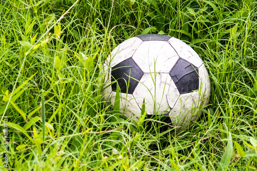 old soccer ball in long grass