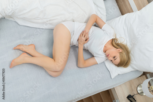 Woman In Bed Suffering From Stomachache