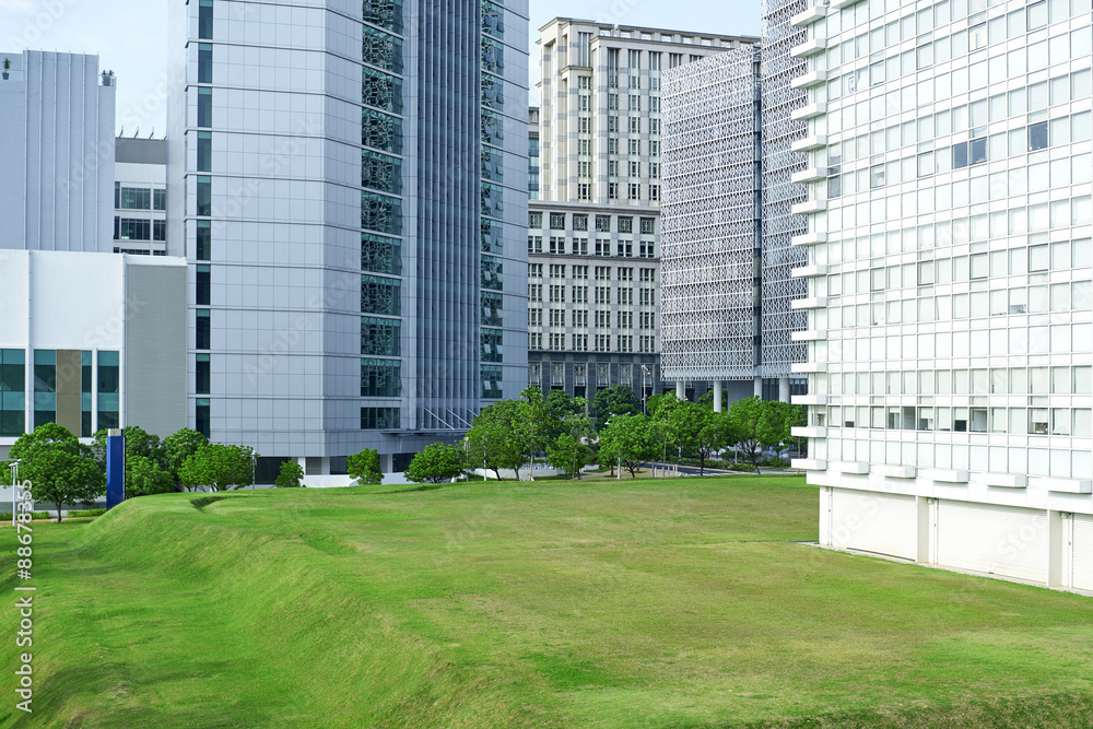 Green park in front of modern office exterior Green park in front of modern office exterior